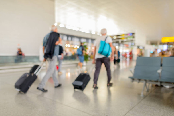 Portrait of defocused terminal departure check-in at airport with walking travelers - Foto, immagini