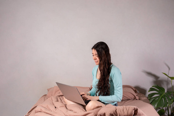 El concepto de distancia social y aislamiento. Trabajar desde casa remotamente a través de Internet. Una joven trabaja en casa con una computadora. Cuarentena
. - Foto, imagen
