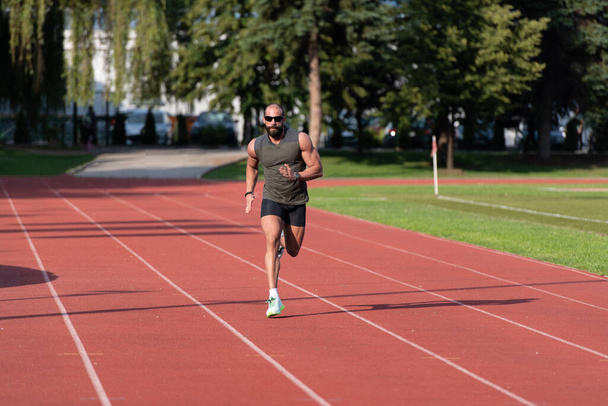 Young Athlete Man Running on Track In Park Run Athletics Race - Foto, afbeelding