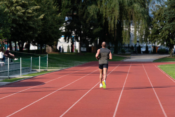 Young Athlete Man Running on Track In Park Run Athletics Race - Zdjęcie, obraz