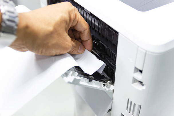 Tecnici che rimuovono carta bloccata, inceppamento di carta nella stampante all'ufficio - Foto, immagini