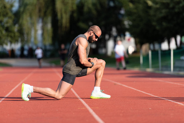 Young Athlete Man Relax and Strech Ready for Run at Athletics Race Track on Stadium - Fotografie, Obrázek