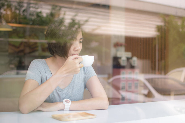 Asiatico donna bere caffè in il caffè in il mattina
. - Foto, immagini