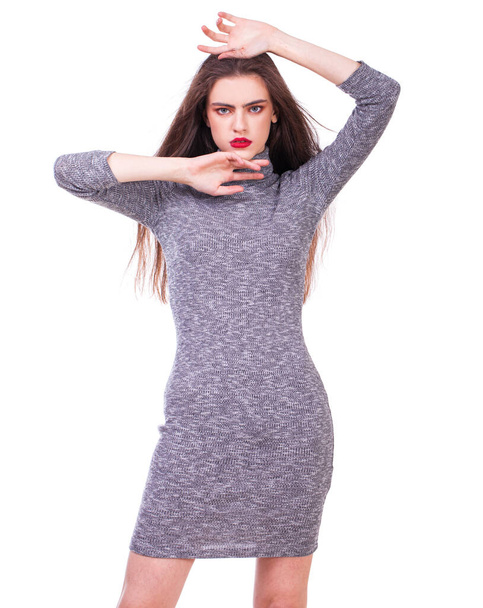 Portrait of a young beautiful girl in a knitted tight-fitting gray dress posing isolated on white background - Zdjęcie, obraz
