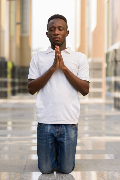 Portrait of young African man at modern building in the city outdoors - Fotografie, Obrázek