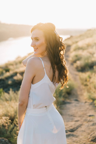 Bride in a luxurious white wedding dress in nature at sunset - Foto, Imagen