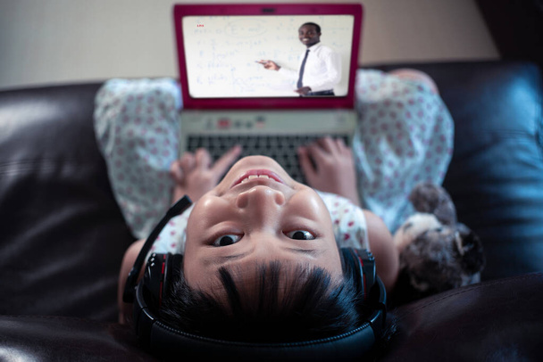Meisje dat thuis op laptop leert, Sociale afstand tijdens quarantaine, Online onderwijs concept - Foto, afbeelding