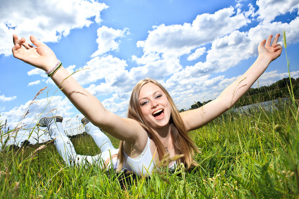Pretty smiling girl relaxing outdoor in green grass - Photo, Image