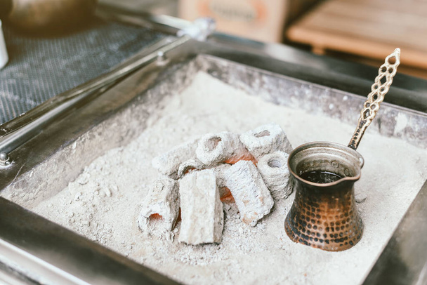 Preparation of Turkish coffee in the cezve in the sand at cafe bar - Photo, Image
