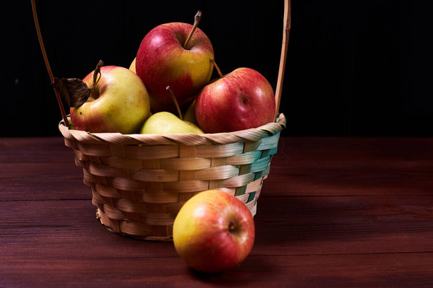 Fresh apples in a basket on a wooden background. - Φωτογραφία, εικόνα