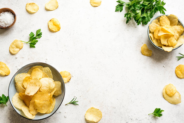Potato chips in bowls. Homemade oven baked crispy potato chips on white background, top view, copy space. - Foto, immagini