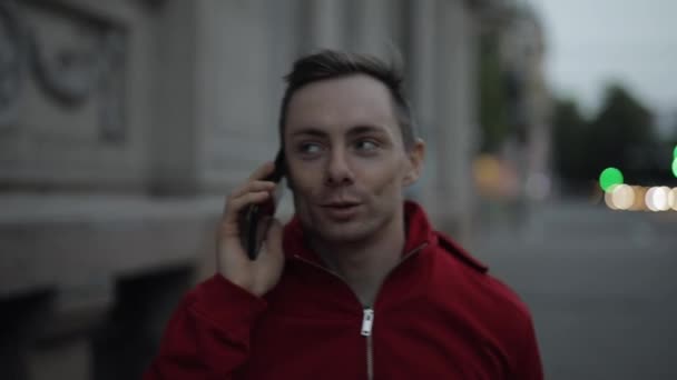 Ο άνθρωπος μιλάει από το smartphone περπατώντας σε ένα δρόμο της πόλης - Πλάνα, βίντεο