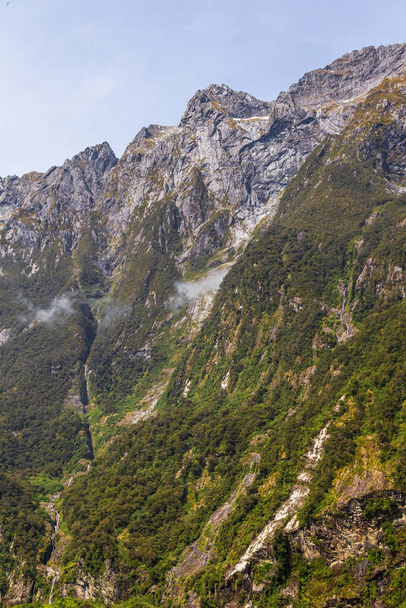 De steile kliffen langs de oevers van de fjord. Nationaal park Fiordland. South Island, Nieuw-Zeeland - Foto, afbeelding