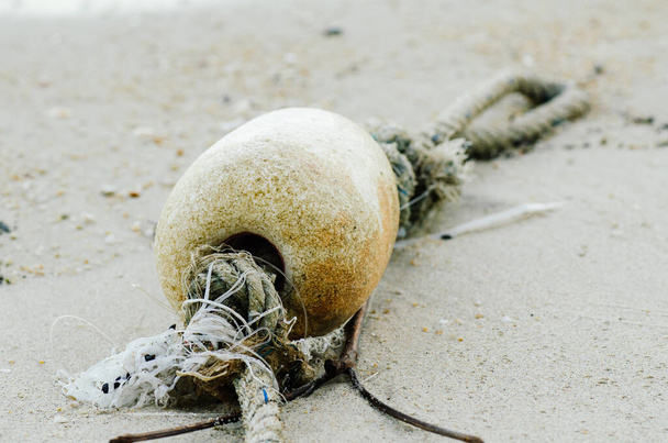 petite bouée de mousse pour flotteur de filet de pêche échouée sur une plage de sable
 - Photo, image