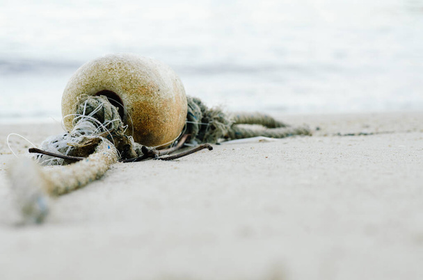 petite bouée de mousse pour flotteur de filet de pêche échouée sur une plage de sable
 - Photo, image