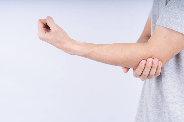 Male touching acute elbow pain on white background with copy space. Medical, healthcare for advertising concept. - Zdjęcie, obraz