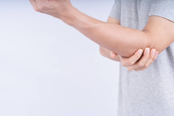 Άνδρας αγγίζει οξύ πόνο στον αγκώνα σε λευκό φόντο με αντίγραφο χώρο. Ιατρική, υγειονομική περίθαλψη για διαφημιστικές ιδέες. - Φωτογραφία, εικόνα