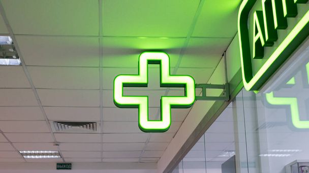Λαμπτήρας πράσινος σταυρός εσωτερικού χώρου κοντά, δείκτης φαρμακείου - Φωτογραφία, εικόνα