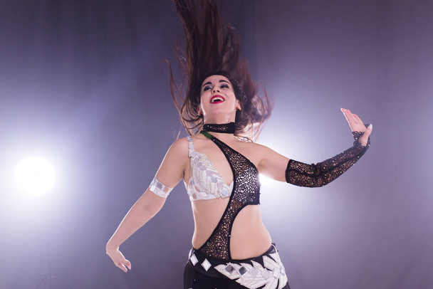 Young woman dancing in Tribal Fusion style. Belly dance on the stage. - 写真・画像