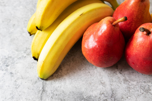 Bananes et poires rouges sur fond clair
 - Photo, image