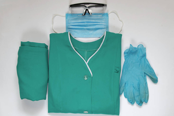 σετ ιατρικής στολής διπλωμένο σε απομονωμένη νοσοκόμα υποβάθρου - Φωτογραφία, εικόνα