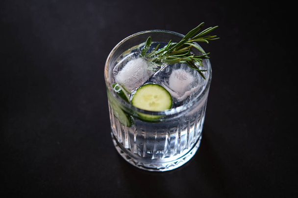 Bevanda alcolica gin tonic cocktail con cetriolo, rosmarino e ghiaccio
 - Foto, immagini