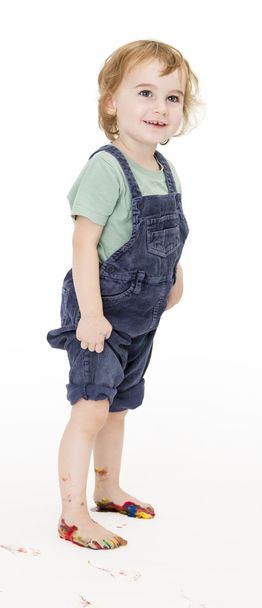 dítě s malovanými nohy drží kalhoty - Fotografie, Obrázek
