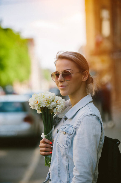 Beautiful and young woman with a bouquet of daffodils - Foto, Imagem