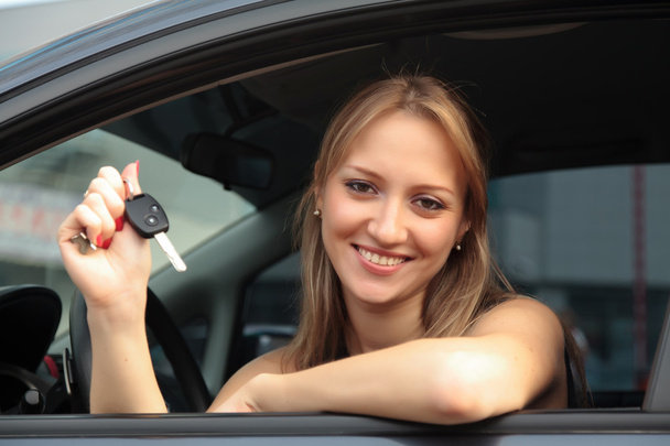 жінка показує ключ від своєї нової машини
 - Фото, зображення