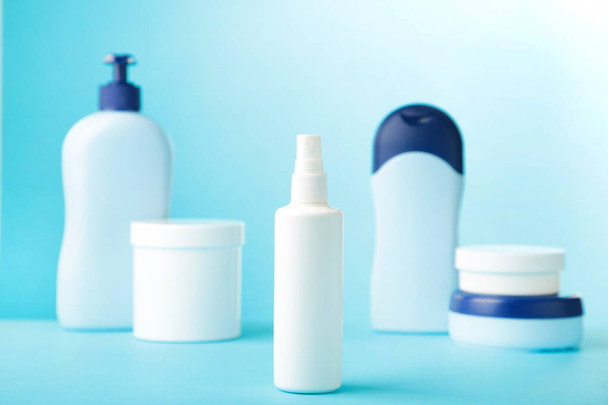 Different cosmetic bottles on blue background. Set of bottles - Foto, imagen
