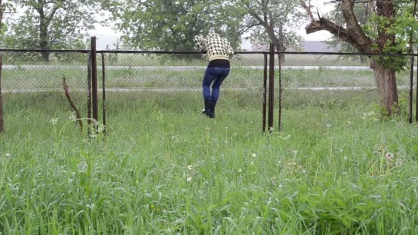 žena stoupání plotem déšť - Záběry, video