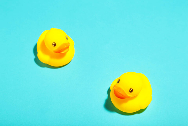 Yellow rubber ducks organized on blue background. Top view - Photo, Image