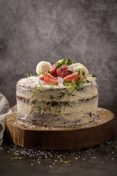 Naked cake with strawberries on kitchen counter top. - Фото, изображение