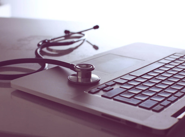 Workplace of doctor with laptop and stethoscope and notebook - 写真・画像