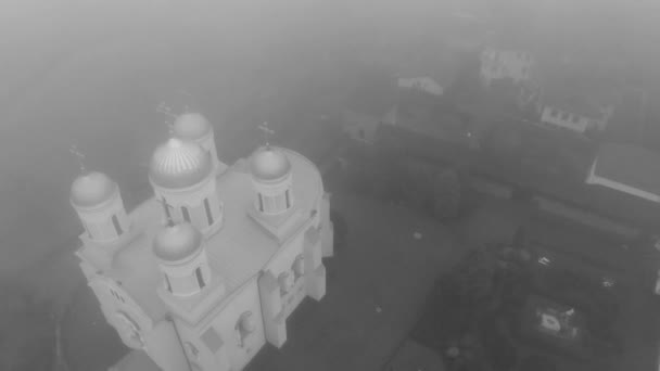 Reggeli repülés a ködben egy ortodox kolostor felett. Fekete-fehér videó. Gyönyörű kilátás nyílik Zimnensky Svyatogorsky kolostor felülről. Kilátás a kupolák és a Nagyboldogasszony katedrális. - Felvétel, videó
