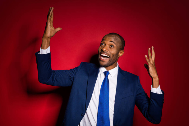 Photo of handsome attractive dark skin business guy successful person raise hands up screaming excited crazy wear formalwear suit tuxedo isolated burgundy red background - 写真・画像