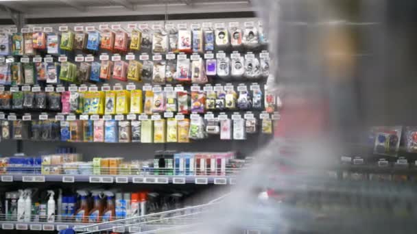 Vásárolni a koronavírus világjárvány idején. Egy nő orvosi maszkban és gumikesztyűben bevásárlókocsit gurít egy szupermarketben.. - Felvétel, videó