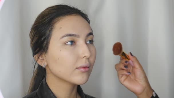 Professional make-up artist applying contour on cheekbones  - 映像、動画