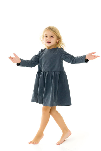 A little girl in a dress is spinning. - Foto, imagen