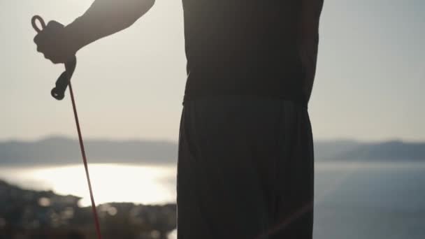 Частина татуйованого чоловіка тренує м'язи на руках з еластичними смугами на відкритому повітрі
 - Кадри, відео