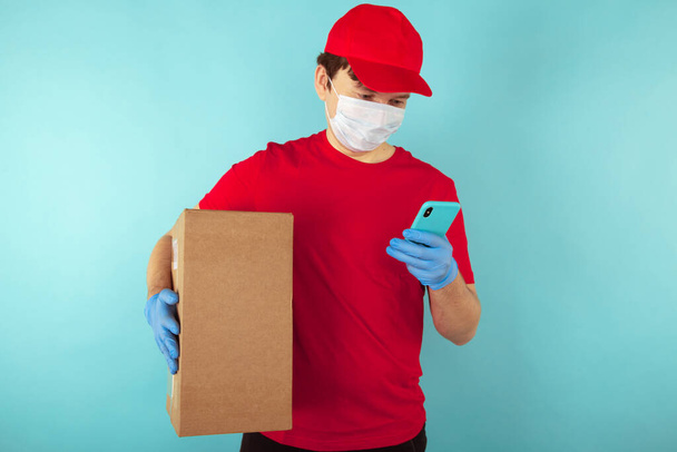 Delivery man holding cardboard boxes in medical rubber gloves and mask. copy space. Fast and free Delivery transport . Online shopping and Express delivery . Quarantine . - Photo, Image