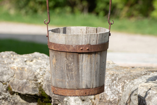 Close up of a old antique wooden bucket hanging over a well - Photo, Image