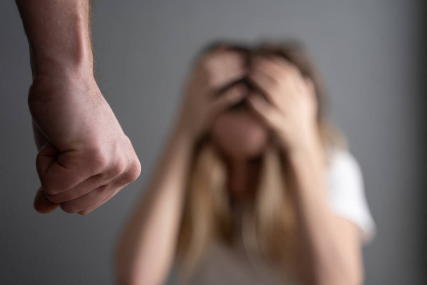 A férj megfenyegeti az ököl feleségét. családon belüli erőszak - Fotó, kép