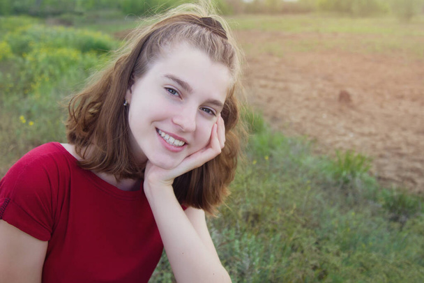 Beautiful young teen girl smiling in a field outdoors. Copyspace. - Valokuva, kuva