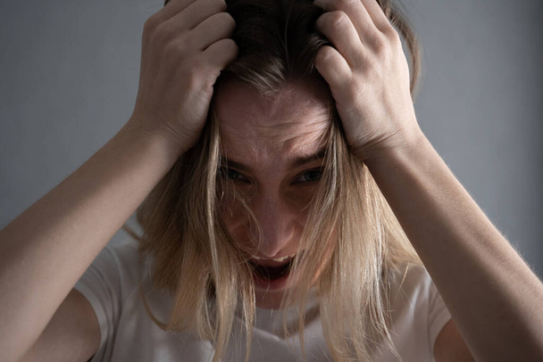 Vue de face d'une femme effrayée criant les mains sur la tête
 - Photo, image
