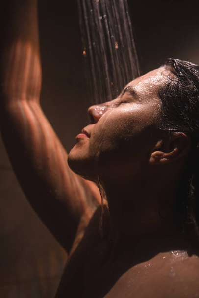 молодая красивая женщина принимает душ. низкий свет. макро
 - Фото, изображение