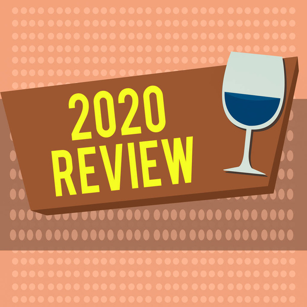 Text sign showing 2020 Review. Conceptual photo remembering past year events main actions or good shows Halftone Goblet Glassware Half filled with Wine on Rectangular shape Form. - Photo, Image