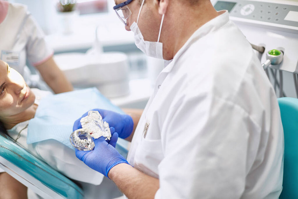 Врач-дантист лечит зубы красивой молодой пациентки. Девушка на ресепшене у дантиста. Доктор дантист лечит зуб - Фото, изображение