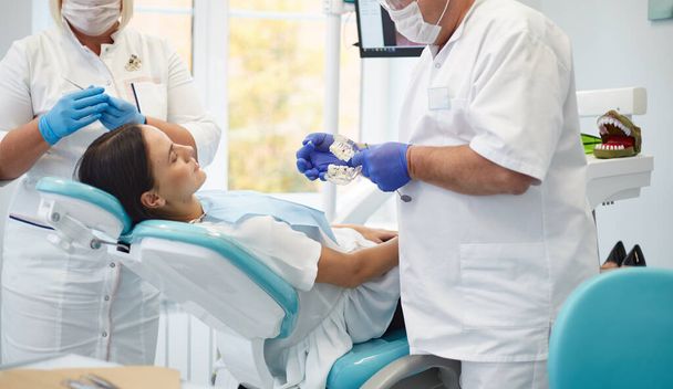 Zahnarzt behandelt Zähne einer schönen jungen Patientin. - Foto, Bild