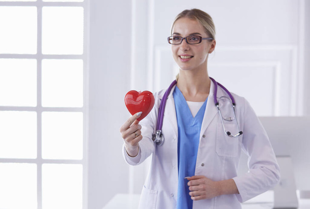 Доктор со стетоскопом держит сердце, изолированное на белом бэкгре
 - Фото, изображение